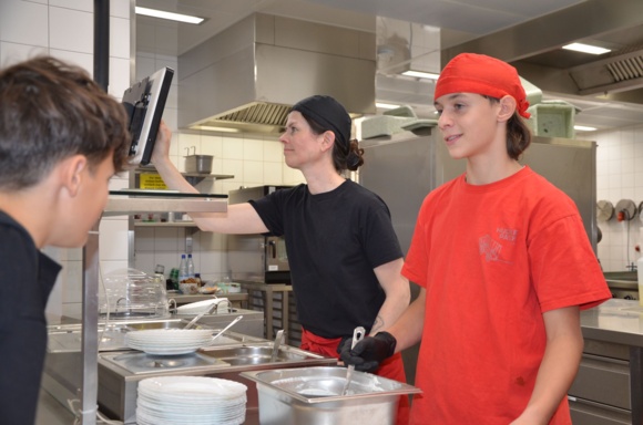 Essenausgabe mit Schüler und Mitarbeiterin