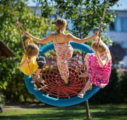 Schulhoföffnung Kinder auf der Vogelnestschaukel