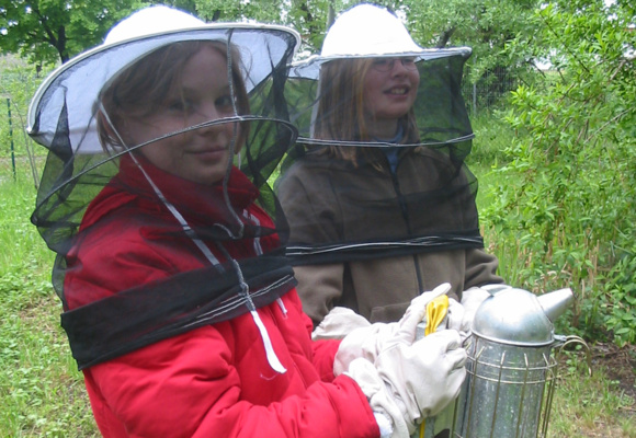 zwei Schülerinnen in Imkerkleidung
