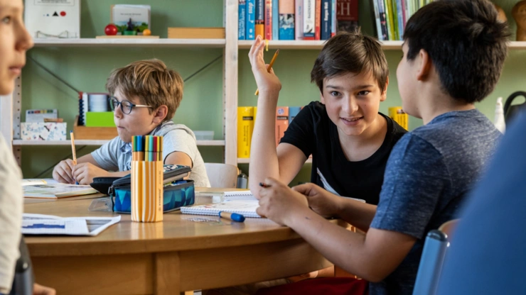 Kinder im Austausch am Tisch.